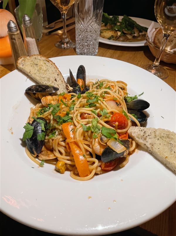Spaghetti di Mare with mussels, prawns and cherry tomatoes, served with garlic bread